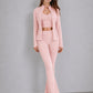 Fitted stand collar zip jacket worn open over a V neck cropped bra with flared pants