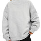 Woman in a light gray mock neck sweatshirt with dropped shoulders and ribbed cuffs, hands resting at the waist