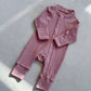 Rose Pink zip front baby romper laid flat on a gray floor, image of the 80 cm, 12 to 18 months size option