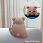 Dusty pink bear resin figurine seen from behind on a laptop lid with a front view inset