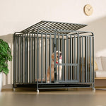 Gray iron dog crate with a peaked roof and wheels holding a golden retriever in a living room