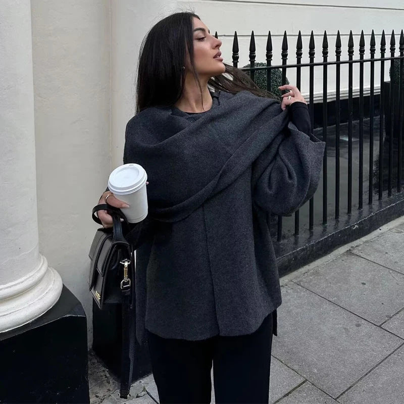 Close view of the asymmetrical draped scarf collar and single neck button