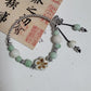 Ceramic beads threaded onto leather cord with a single clasp as a pendant