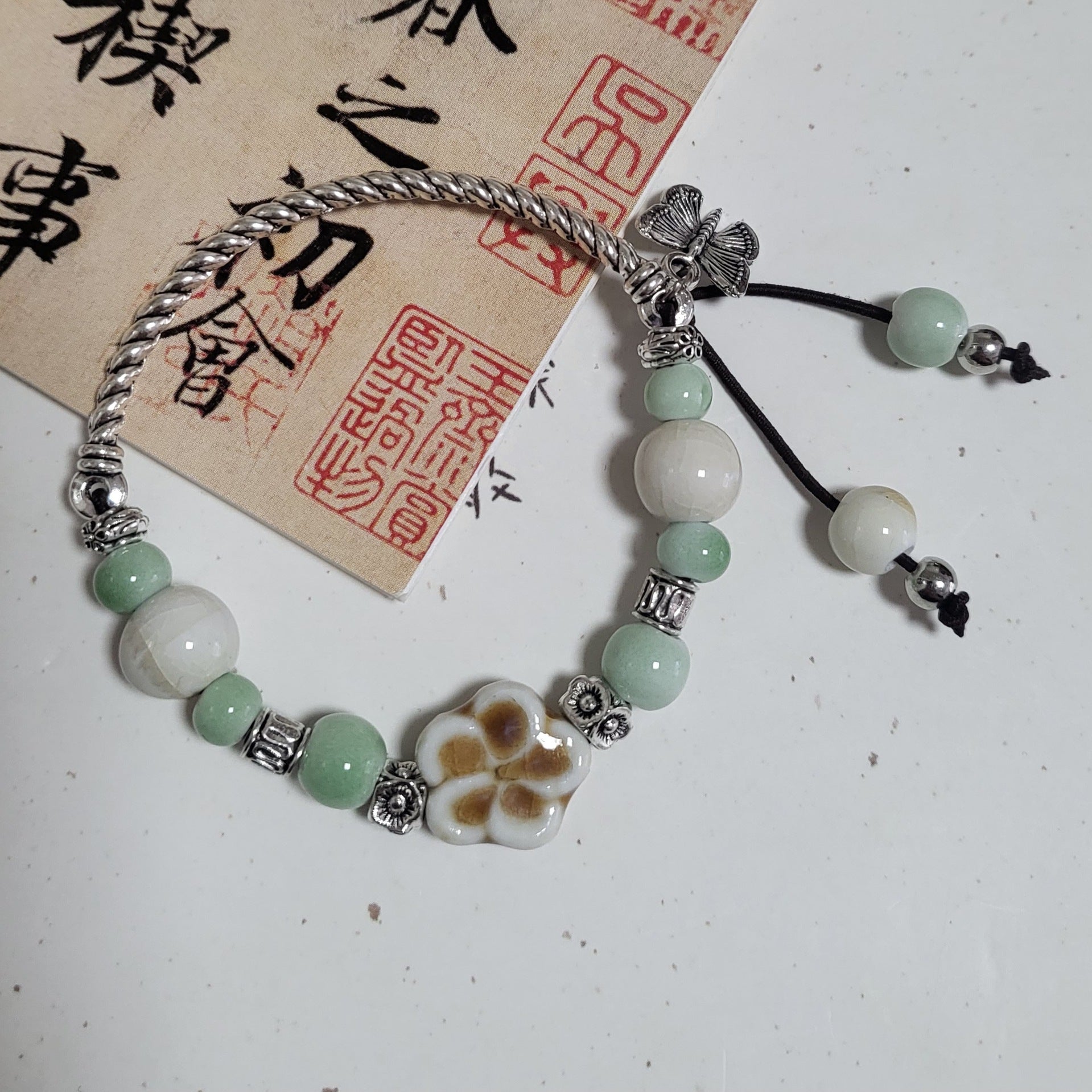Ceramic beads threaded onto leather cord with a single clasp as a pendant