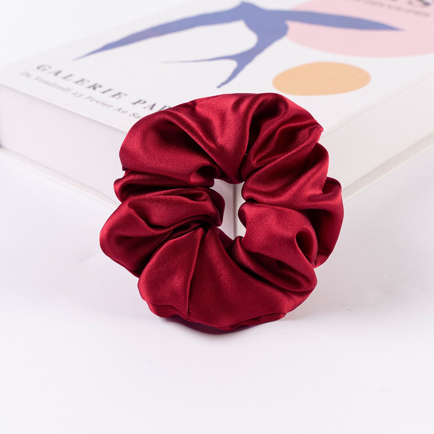 Satin scrunchie shown holding a ponytail