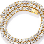 Close view of a gold plated tennis chain necklace with round clear stones in prong settings and a box clasp