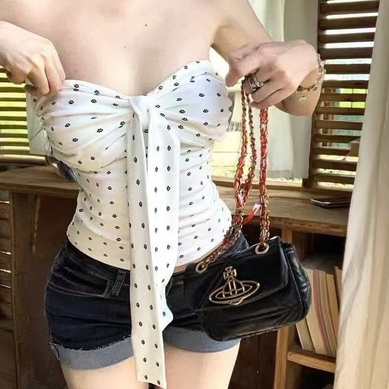 Close view of the white floral tube top self-tie bow knotted at the center of the bust