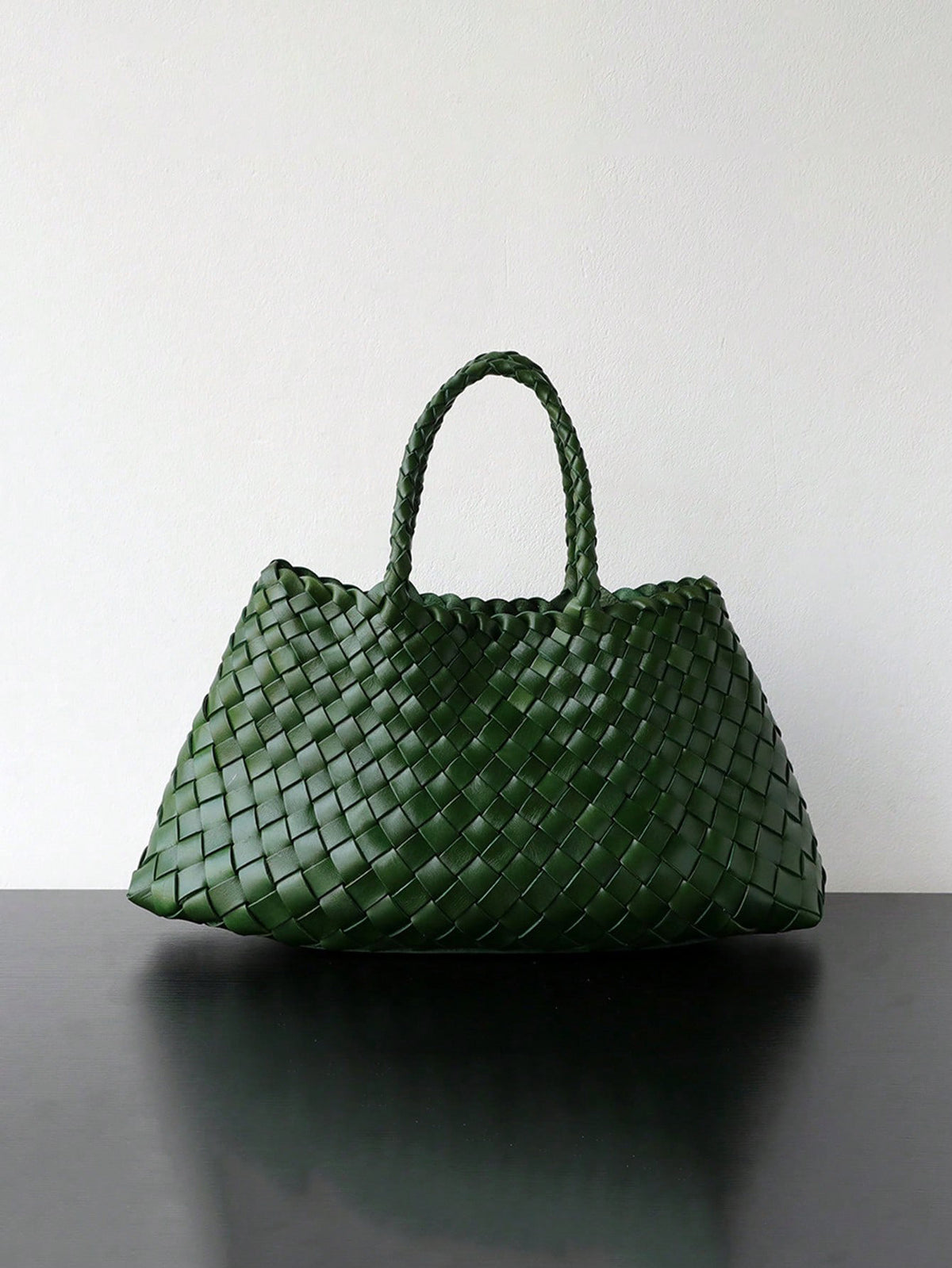 Dark green woven handbag with braided handles standing on a dark surface, Dark green variant