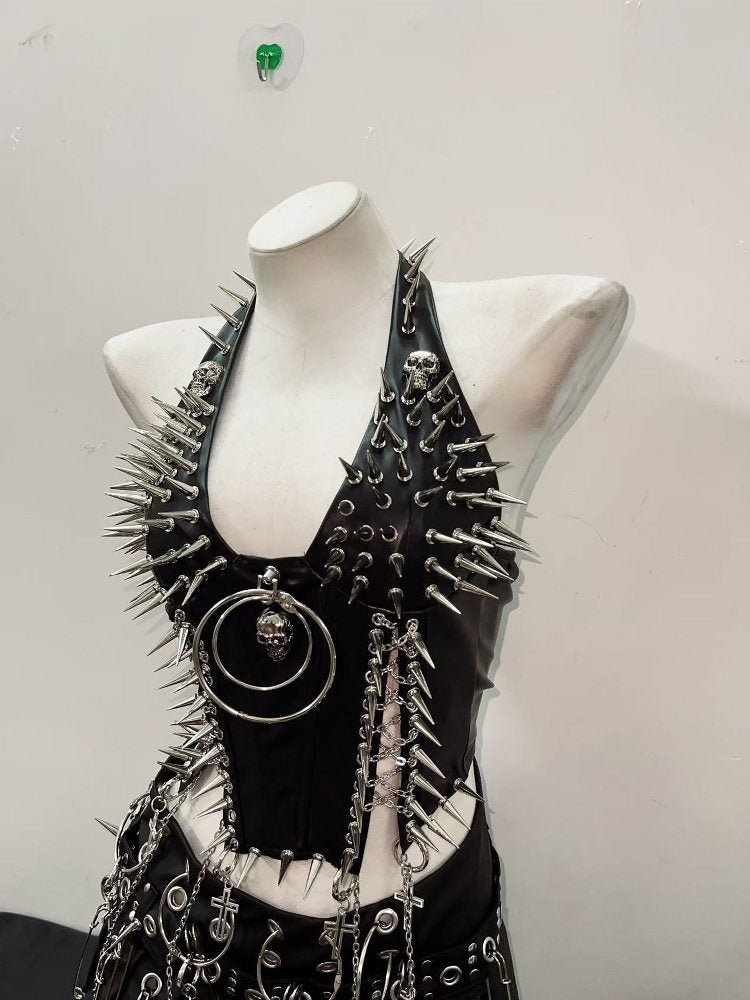 Side angle of studded punk vest showing spiked panels, skull charms and cross chains
