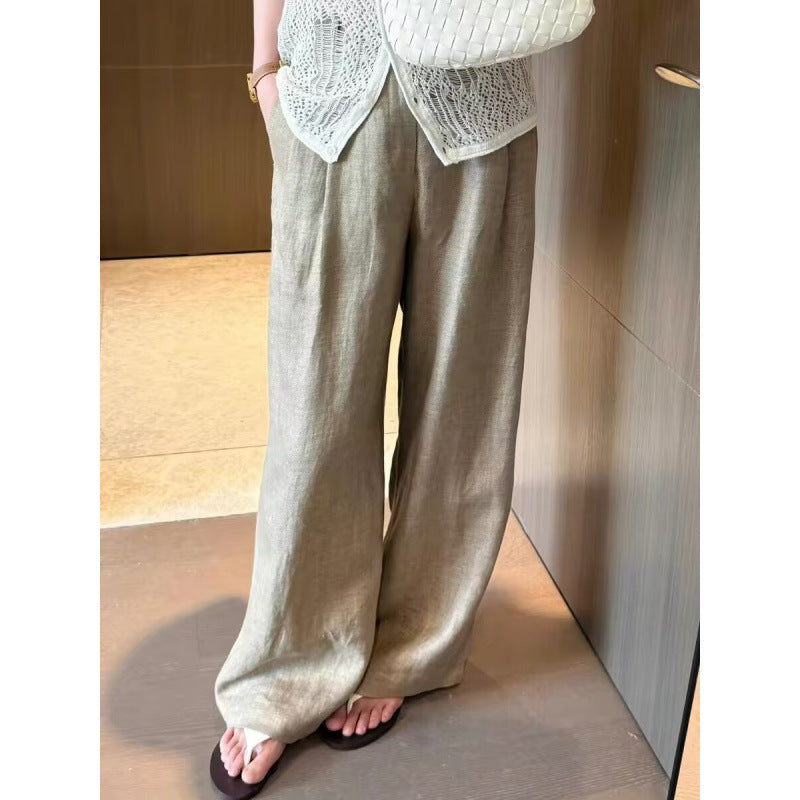Woman wearing khaki wide-leg pants with a white knit top and flat sandals