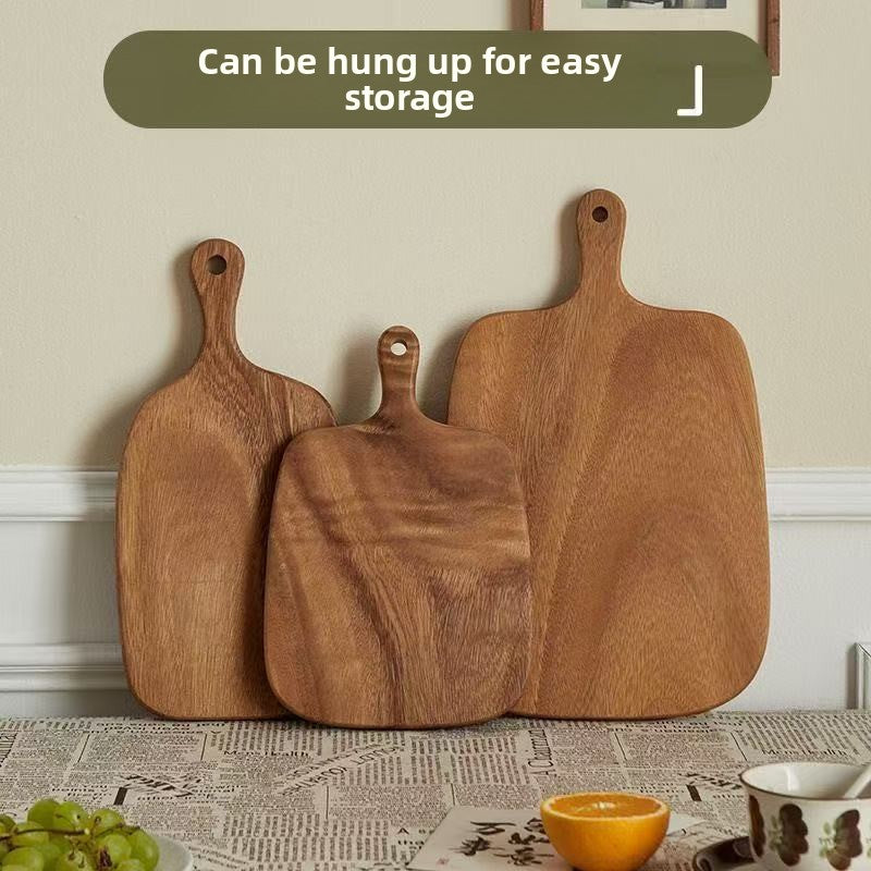 Solid walnut wood cutting board with a natural dark grain shown on a kitchen counter