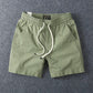 Army green men's cotton drawstring shorts framed close on the waist and flat cotton drawstring