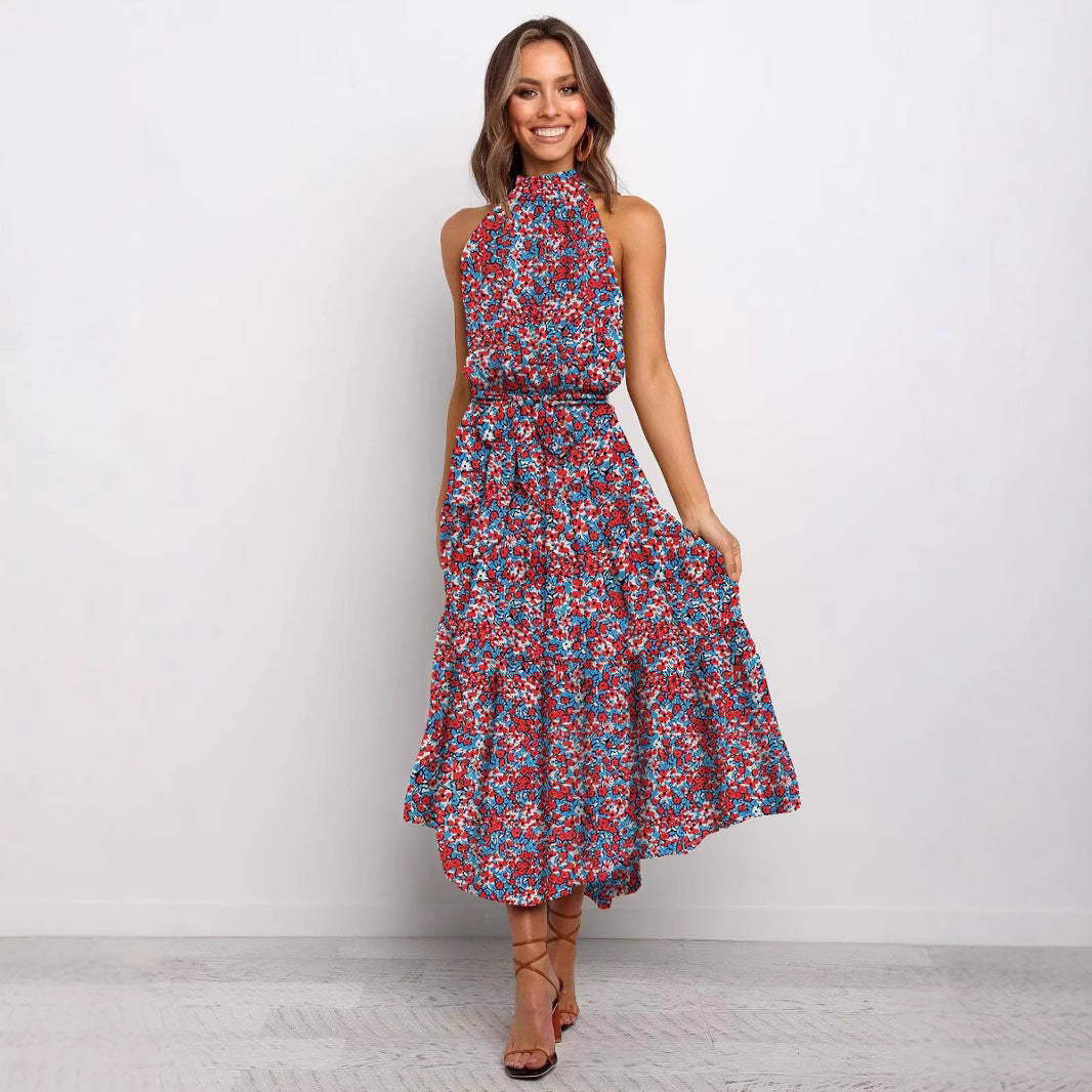 Red and purple floral halter neck sleeveless tiered swing maxi dress worn by a model