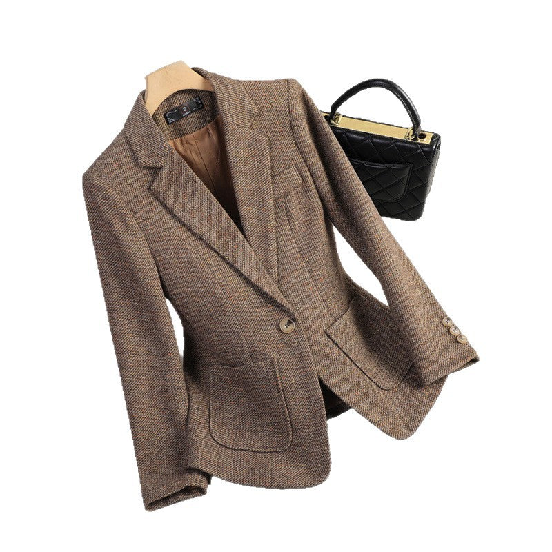 Brown herringbone tweed blazer on a hanger, front view with notch lapel, single button and tan lining