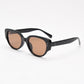 Black oval cat eye frame with brown tea tinted lenses at an angle