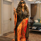 Model in the black and orange tie dye satin caftan gown over matching wide leg trousers