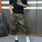 Camo denim cargo shorts with intentional rips and a navy patch, worn with white socks and black clogs
