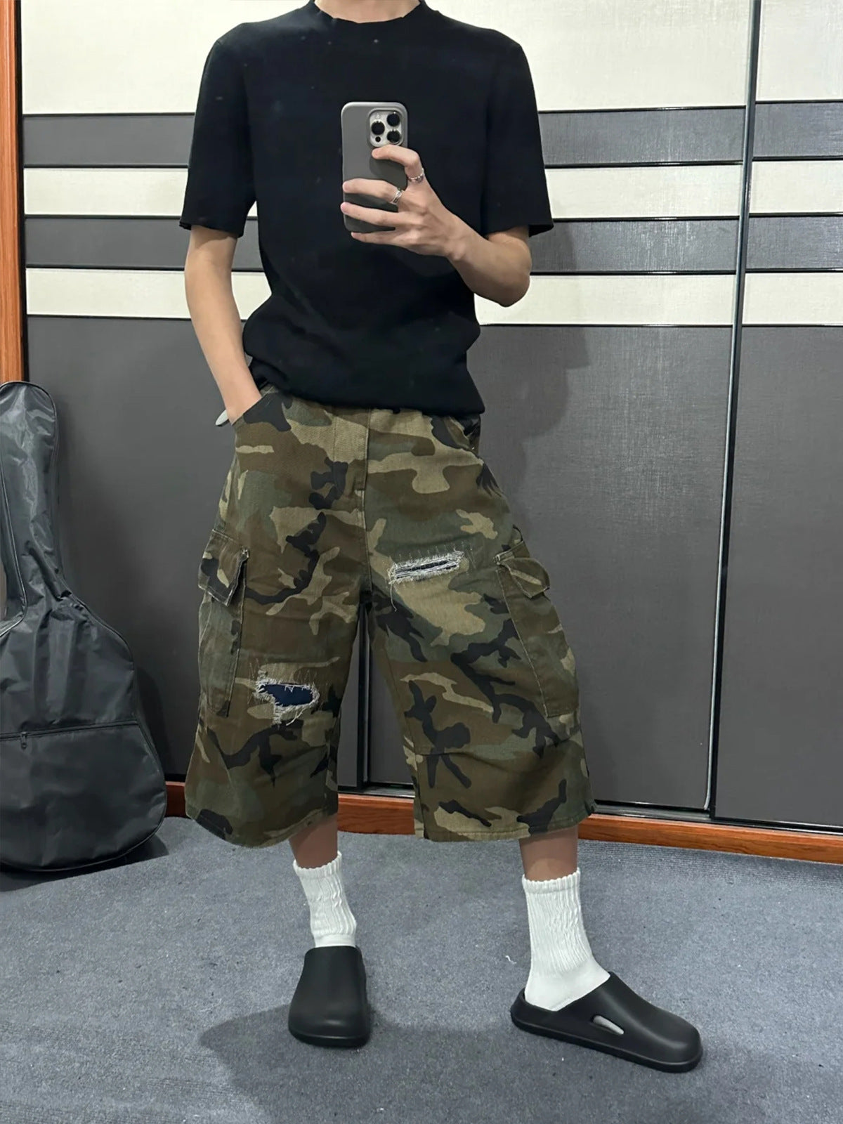 Camo denim cargo shorts with intentional rips and a navy patch, worn with white socks and black clogs