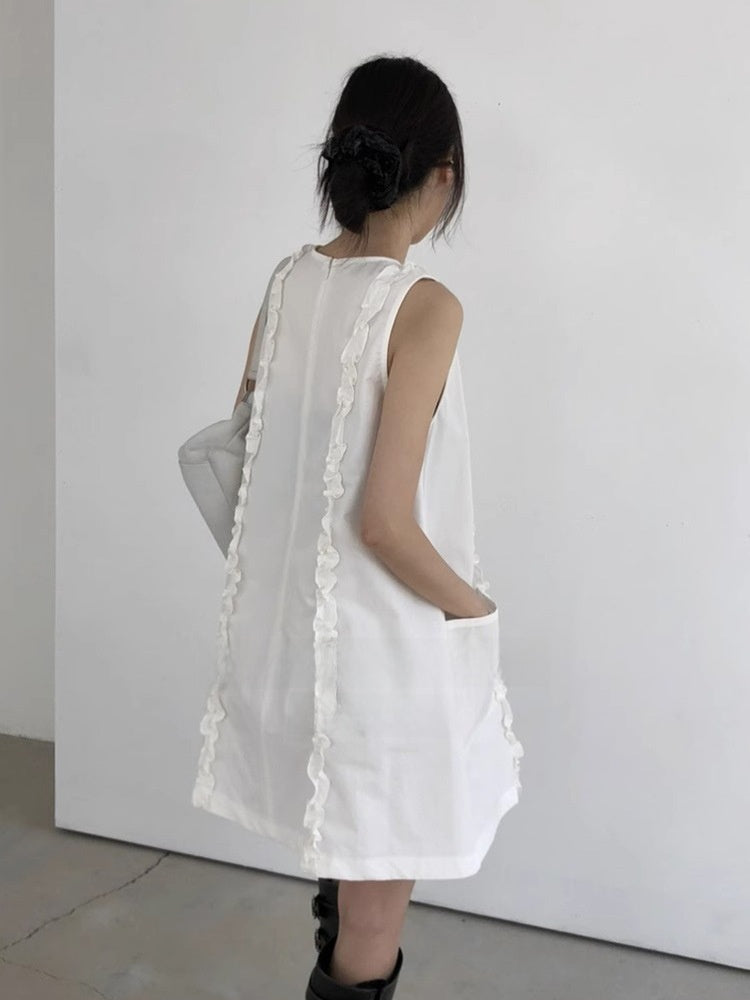 White sleeveless ruffle trim A-line mini dress shown from the back with shoulder bag