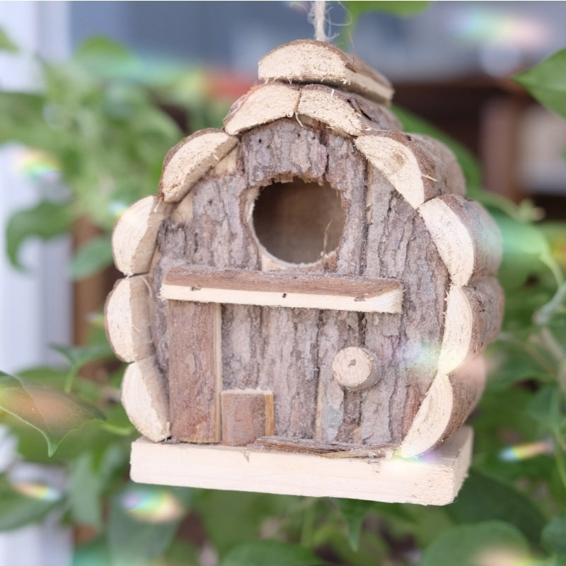 Front view of pine birdhouse with small songbird entry hole