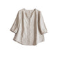 White linen V neck shirt with a curved dropped hem shown on a model