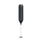 Black handheld electric milk frother with round power button and spring whisk on a plain background