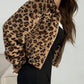 Side view of a cropped leopard vegan fur zip jacket with long sleeves on a studio model