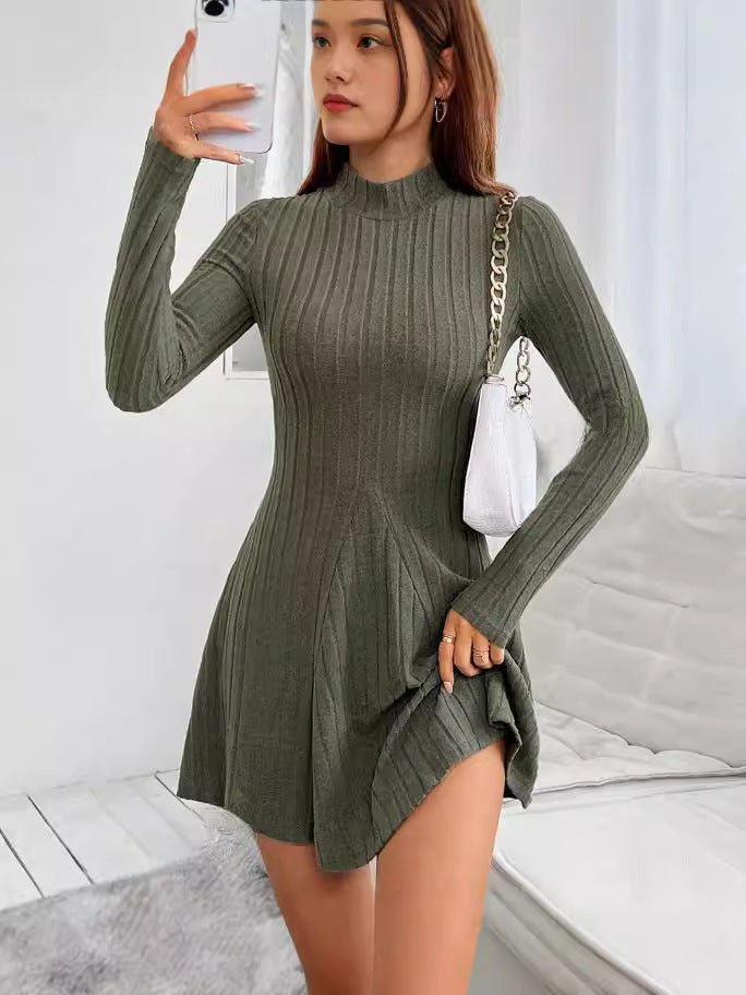 Military green ribbed knit mock neck long sleeve fit and flare mini dress worn with a white chain shoulder bag
