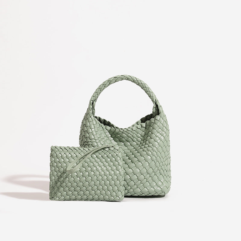 Sage green woven PU leather bucket bag with plaited handle beside its matching green zip pouch