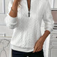 Angled view of a womens quarter zip cable knit pullover in a solid color