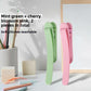 Two piece set of silicone bookmark clips in mint green and sakura pink on a desk