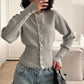 Black rib knit cardigan worn buttoned as a fitted top with jeans