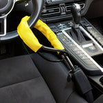 Yellow sleeved steering wheel lock looped around the wheel and plugged into the seat belt buckle