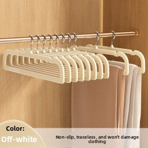 Off-white pants hangers on a wardrobe rail with trousers draped over the bars