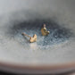 Side profile of the gold-tone heart earring showing the curved edge and post