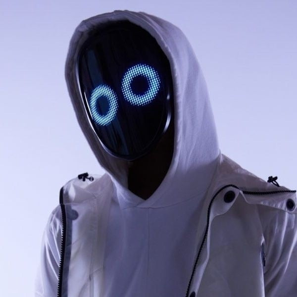Person in a white hoodie wearing the black LED mask with two glowing blue ringed eyes on the display