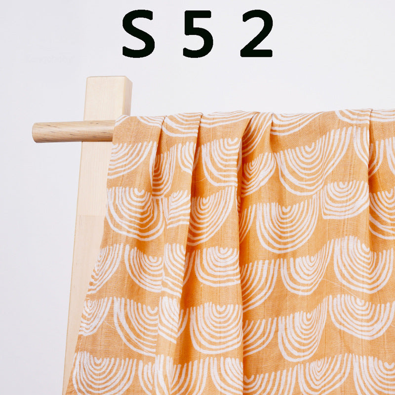 Pure cotton muslin swaddle blanket rolled up, showing the airy gauze texture and printed design