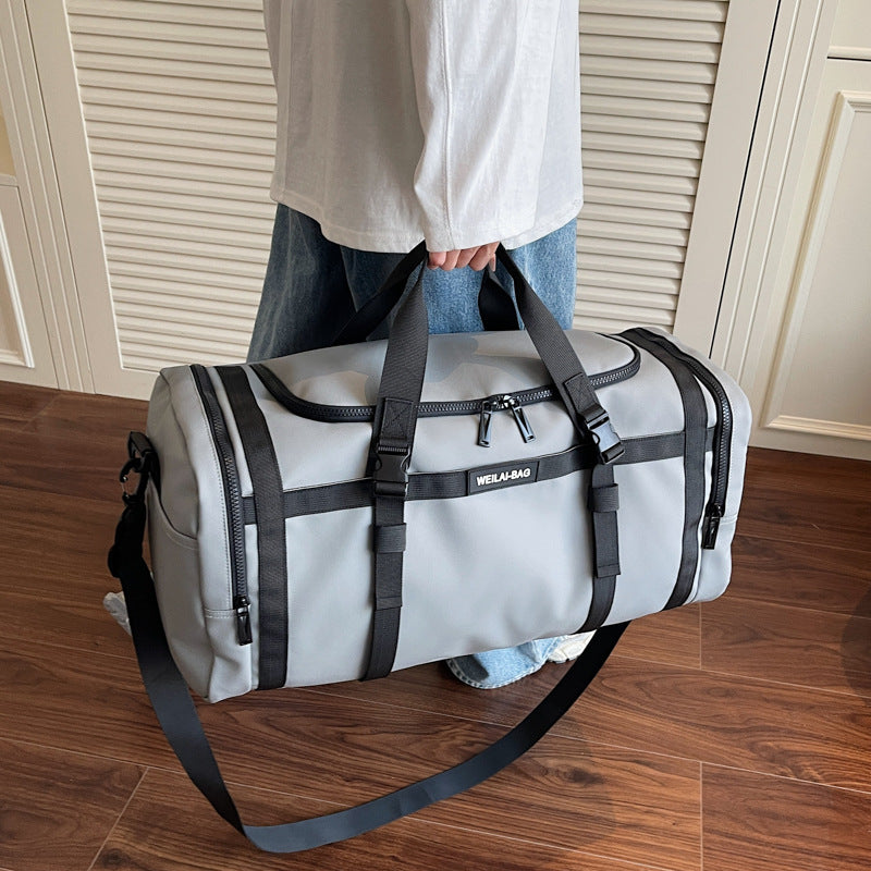 Travel duffel bag shown from the front with its top zip, grab handles and front straps