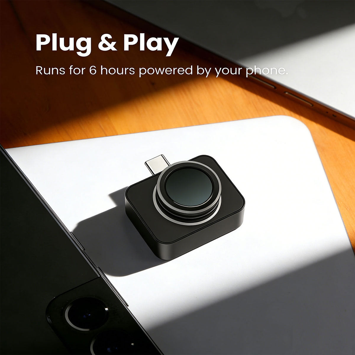 Black thermal camera plugged into a phone on a desk, labelled plug and play powered by the phone