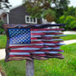 Carved teak American flag wall art mounted on a post outside a home