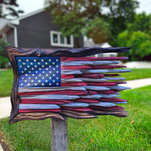 Carved teak American flag wall art mounted on a post outside a home