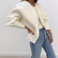 Cream faux pearl trimmed knit cardigan worn open, pearl beads along the front edge and hem