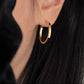 Side profile of model wearing the minimalist gold hoop with a black turtleneck