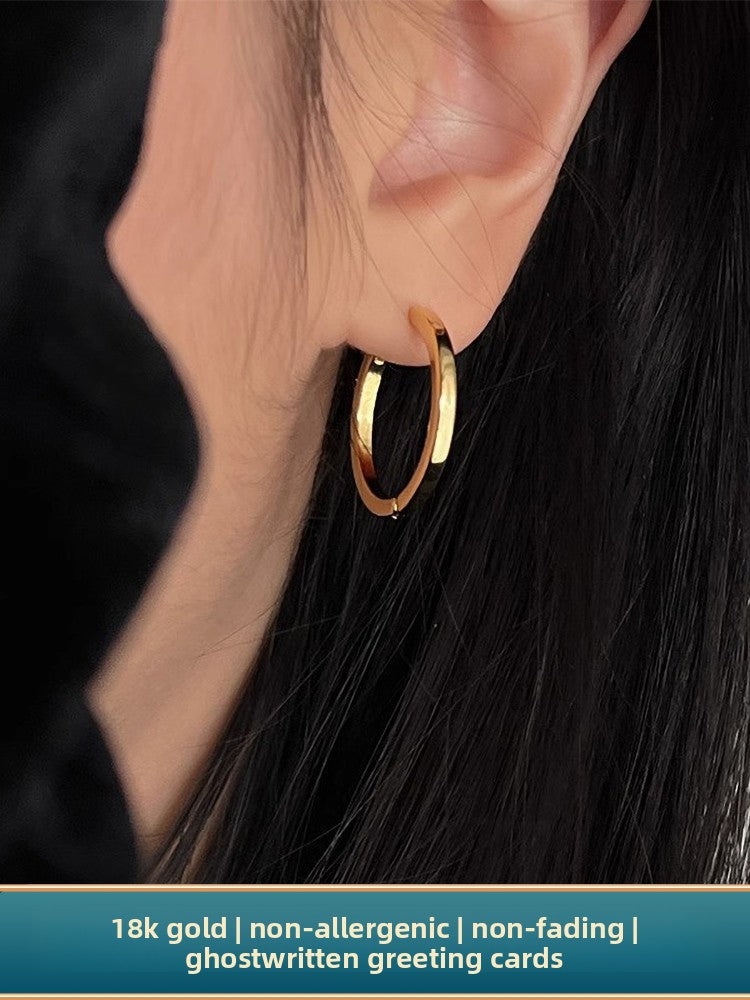 Side profile of model wearing the minimalist gold hoop with a black turtleneck
