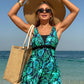 Green leaf print swimdress shown from a wading angle at the shoreline