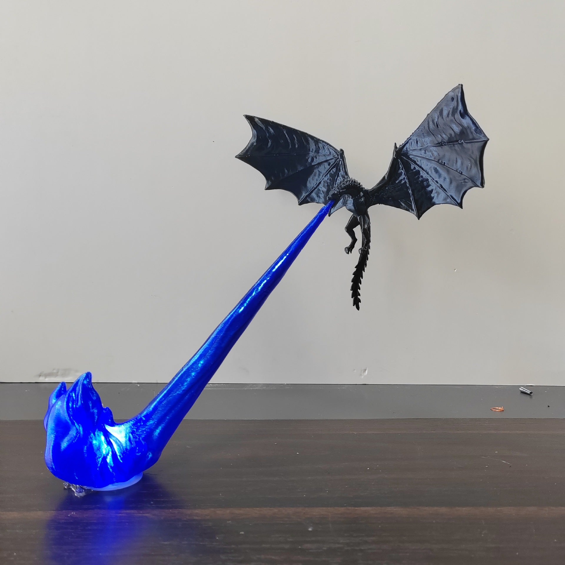 Black dragon ornament with a red flame beside the same design in blue