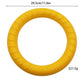 Yellow EVA foam dog fetch ring held by a black and white dog in a green yard