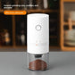 White electric coffee grinder with a power button and ground coffee in a clear cup, ceramic grinding core text overlay