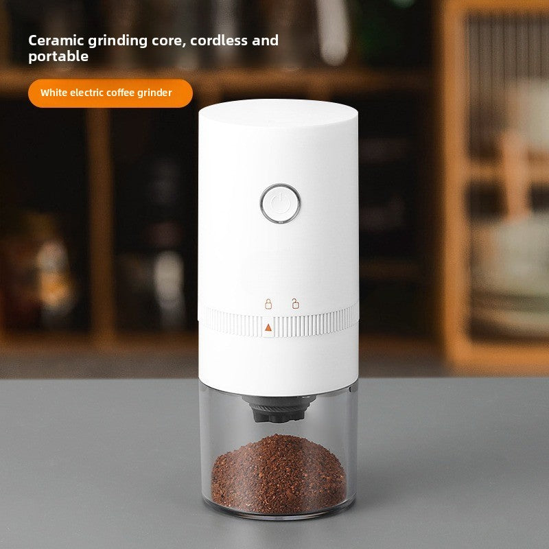 White electric coffee grinder with a power button and ground coffee in a clear cup, ceramic grinding core text overlay