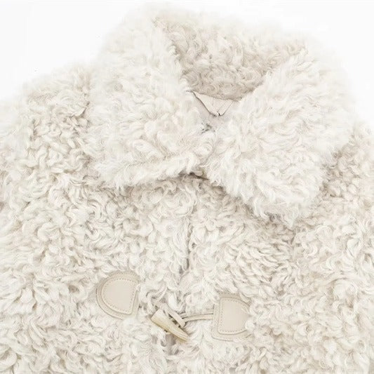 Close view of the cream curly fleece lapel collar and toggle fastener on a jacket